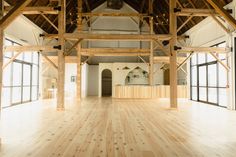 an empty room with wooden floors and large windows