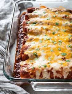 an enchilada casserole in a glass baking dish on a towel