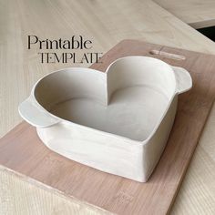 a heart shaped bowl sitting on top of a cutting board