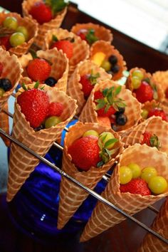 several cones filled with fruit sitting on top of a table