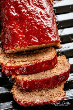 sliced meatloaf on a grill with ketchup spread over the top and sides