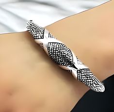 Elevate your jewelry collection with our exquisite 925 Sterling Silver Bangle Bracelet, featuring a charming snakeskin- dot design. This piece is meticulously crafted with a spring hinge for effortless wear and a secure fit. The bracelet's lightweight construction ensures comfort without compromising on style. With an inside circumference of 6 3/4 inches (17.2 cm), it is designed to gracefully encircle your wrist. Each bracelet is stamped with '925' as a testament to its sterling silver purity. The hollow design of the bangle allows for a luxurious look while maintaining a comfortable feel for daily wear. This elegant accessory is perfect for both casual and formal occasions, adding a touch of sophistication to any outfit. Invest in timeless elegance with this sterling silver bangle, a ver Silver Bangle Bracelet, Sterling Silver Bangle Bracelets, Sterling Silver Bangle, Hollow Design, Dot Design, Dots Design, Sterling Silver Bangles, Silver Bangle, Spring Hinge