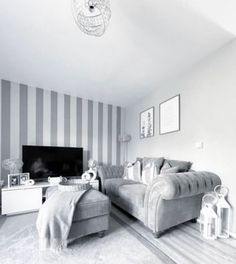 a black and white photo of a living room with striped wallpaper on the walls