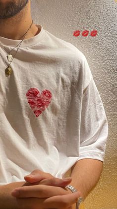 a man wearing a white t - shirt with a heart on it's chest