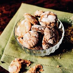 a glass bowl filled with powdered sugar cookies