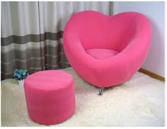 a pink heart shaped chair and foot stool in a living room with white rugs