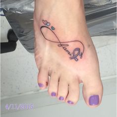 a woman's foot with a tattoo on it that has a heart and an arrow