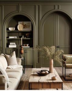 a living room filled with lots of furniture and walls covered in green painted wood paneling