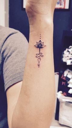 a woman's wrist with a lotus tattoo on it