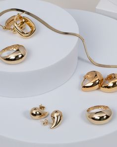 gold jewelry is displayed on a white surface