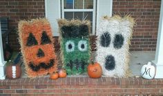 three decorated pumpkins sitting on top of a window sill next to hay bales