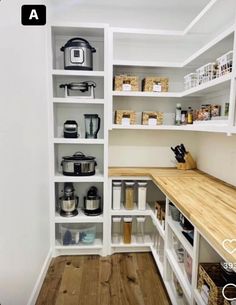 an organized pantry with white shelving and wooden counter tops