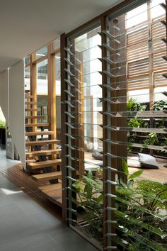 the inside of a house with wooden stairs and glass doors that lead to an outdoor deck