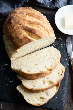 a loaf of bread sitting on top of a cutting board next to a knife and butter