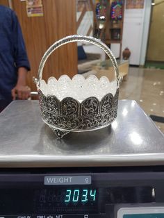 a silver basket sitting on top of a scale