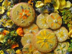 there are some cookies with flowers on them and one has yellow icing in the middle