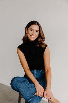 a woman is sitting on a chair and smiling