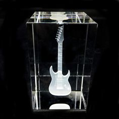 an electric guitar in a clear case with black back ground and white neckplates