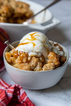 two bowls filled with ice cream next to an apple and another bowl full of dessert