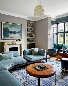 a living room with couches, chairs and a table in front of a window