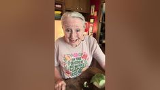 an older woman is making a face while cutting vegetables on a cutting board in her kitchen