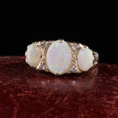 Beautiful Antique Victorian English 10K Yellow Gold Opal three Stone Ring. This gorgeous ring is crafted in 10k yellow gold. The ring holds three beautiful opals that have beautiful color play. There are small old cut diamonds in between the prongs that accent the opals beautifully. The ring is in great condition and has hallmarks inside the ring as well. Item #R1534 Metal: 10K Yellow Gold Weight: 4 Grams Size: 10 1/4 Opals: Approximately 3 cts Side Diamonds: Approximately .08 cts Color: H Clari Victorian Diamond Ring, 3 Stone Diamond Ring, Watch Cufflinks, Antique Jewelry Rings, Heart Band, Antique Wedding Rings, Gorgeous Ring, Color Play, Three Stone Ring