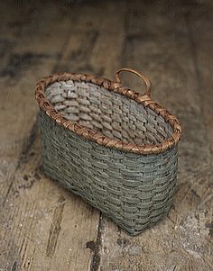 a small basket sitting on top of a wooden floor