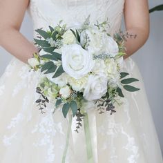 a bridal holding a bouquet of white flowers