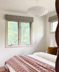 a bed sitting under a window in a bedroom