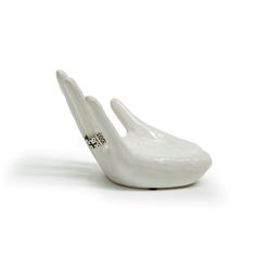 a white ceramic bird figurine on a white background