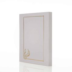 a white box with gold foil on the front and bottom, sitting against a white background