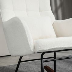 a white chair sitting on top of a carpeted floor next to a wooden frame