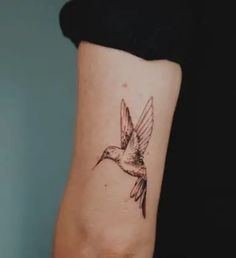 a small bird tattoo on the arm