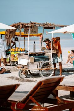 people are on the beach near an ice cream cart