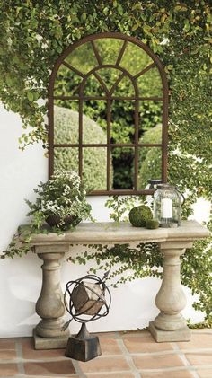 a table with a mirror on top of it and some plants in front of it