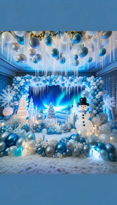 a room decorated with blue and white christmas balls, snowmen, and lights on the ceiling