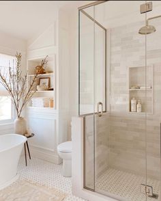 a bath room with a toilet a tub and a shower head mounted to the wall