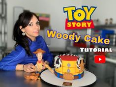 a woman sitting in front of a toy story woody cake