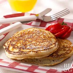 two pancakes are on a plate with strawberries