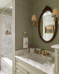 a bathroom with marble counter tops and gold fixtures