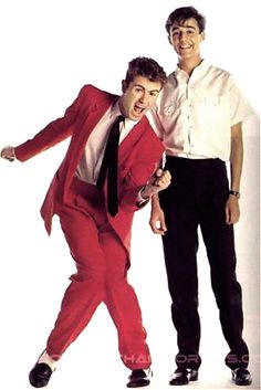 two men in red suits are posing for the camera