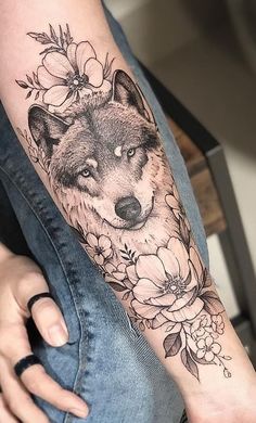 a woman's arm with a wolf and flowers on it