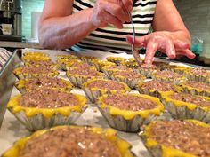 a woman is making cupcakes with yellow icing on the top and brown sugar on the bottom