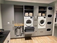 a washer and dryer in a room with wood flooring on the side