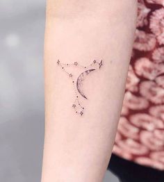 a woman's arm with a star and crescent tattoo on the left inner arm