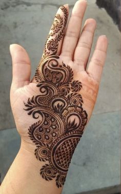 a hand with henna on it that is in someone's left hand and has an intricate design