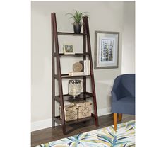 a ladder shelf with baskets on it next to a blue chair and potted plant