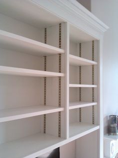 a white bookcase with several shelves in it