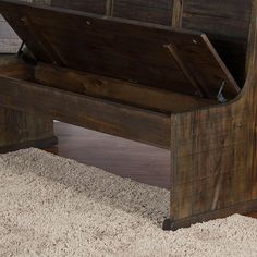 a wooden bench sitting on top of a carpeted floor next to a white rug