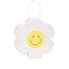 a yellow and white flower with a smiley face on it's center, hanging from a string